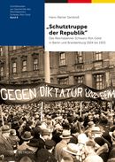 Dunkelblaues Buchcover mit einem horizontalen schwarz-rot-gelben Streifen und einem historischen Schwarz-Weiß-Foto: die Straße vor einem mehrstöckigen Wohnhaus ist voll von Menschen. Im Zentrum des Bildes sieht man ein langes Banner, auf dem steht: Gegen Diktatur und Gewa[lt]. Unten links das Logo des Metropol Verlags.